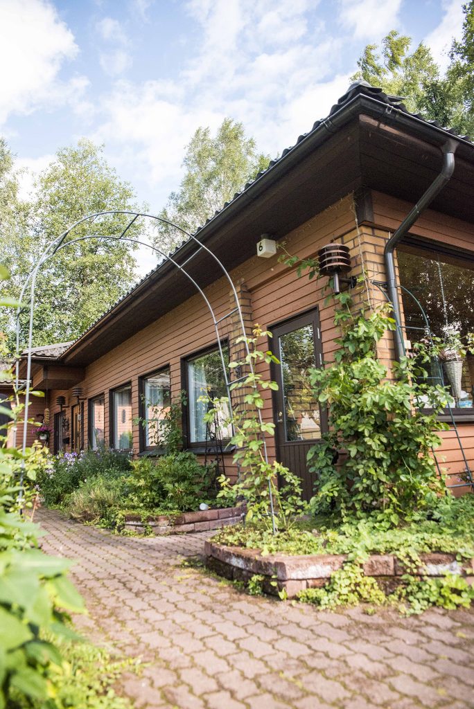 Kesäinen kuva yksikerroksisesta omakotitalosta